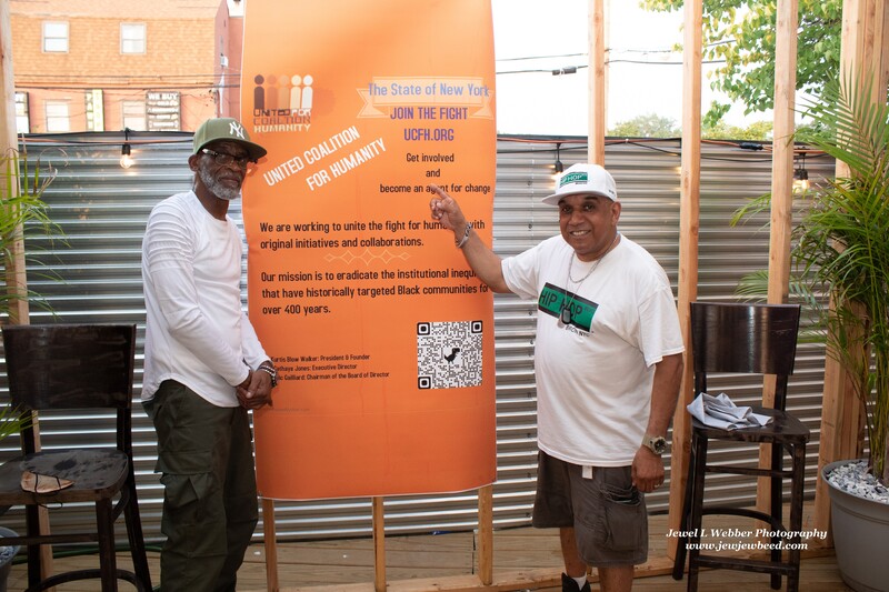 Ray Carter poses near United Coalition For Humanity banner with Al Pizarro, Co-founder of Hip-Hop BLVD NYC